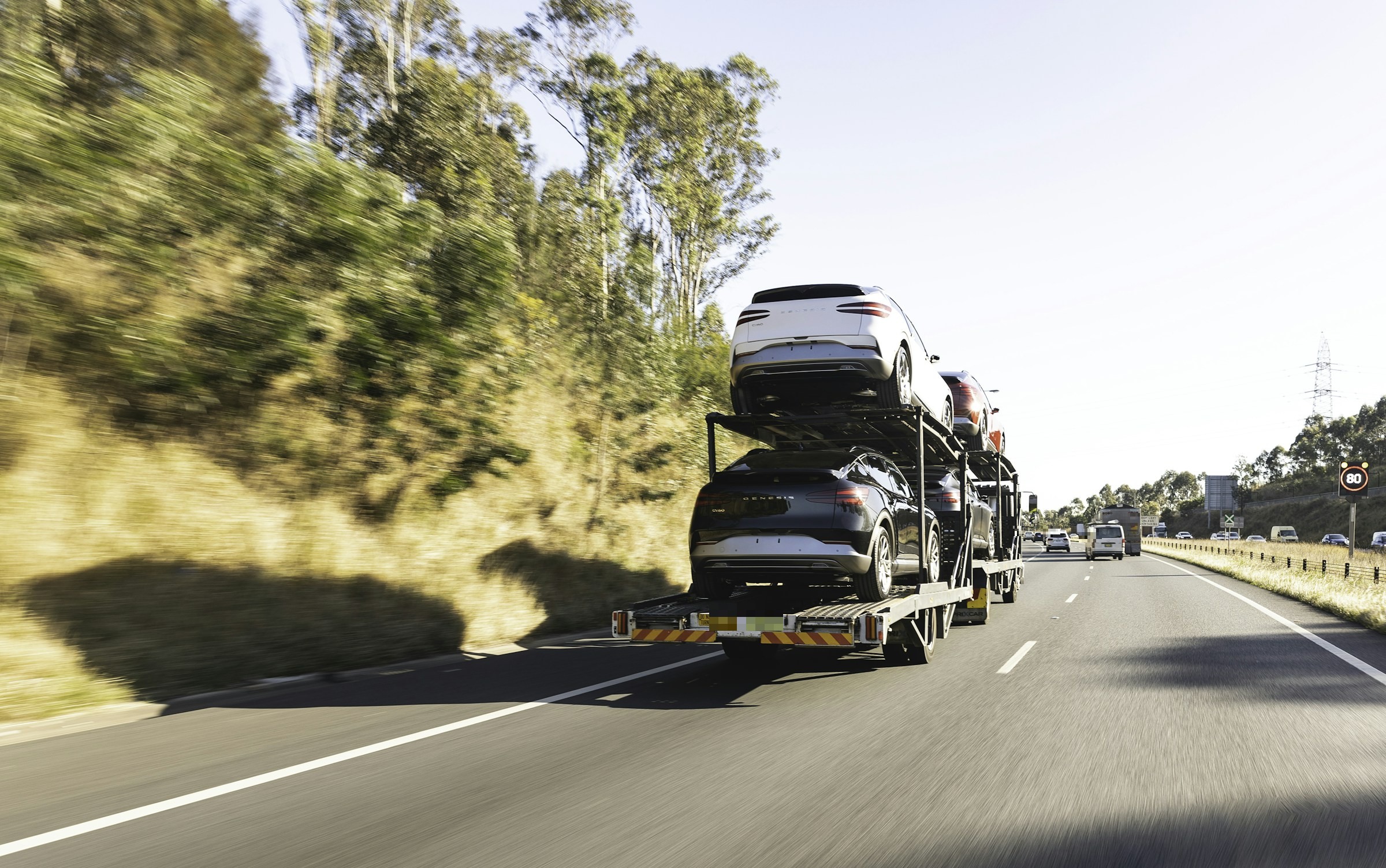 Vehicles secured on a carrier traveling along a highway